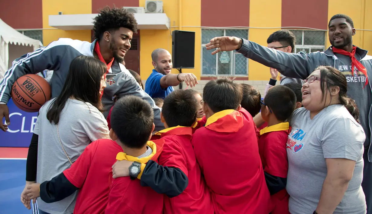 Pemain New Orleans Pelicans, Shawn Dawson dan E'Twaun Moore berbincang dengan para siswa selama sesi latihan di Sekolah Migran Huangzhuang, Beijing, Tiongkok (11/10). (AP Photo/Ng Han Guan)