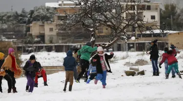 Sejumlah anak pengungsi Suriah bermain dengan salju di Aley, Lebanon, Jumat (1/12/2016). Badai salju di Lebanon menambah kesengsaraan puluhan ribu pengungsi Suriah yang tinggal di tempat penampungan sementara wilayah tersebut. (REUTERS/Jamal Saidi)