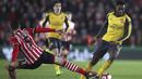 Danny Welbeck mencoba melewati hadangan pemain Southampton, Florin Gardos pada putaran keempat Piala FA musim 2016-2017 di St Mary's Stadium,  (28/1/2017. Arsenal menang 5-0. (Nick Potts/PA via AP)