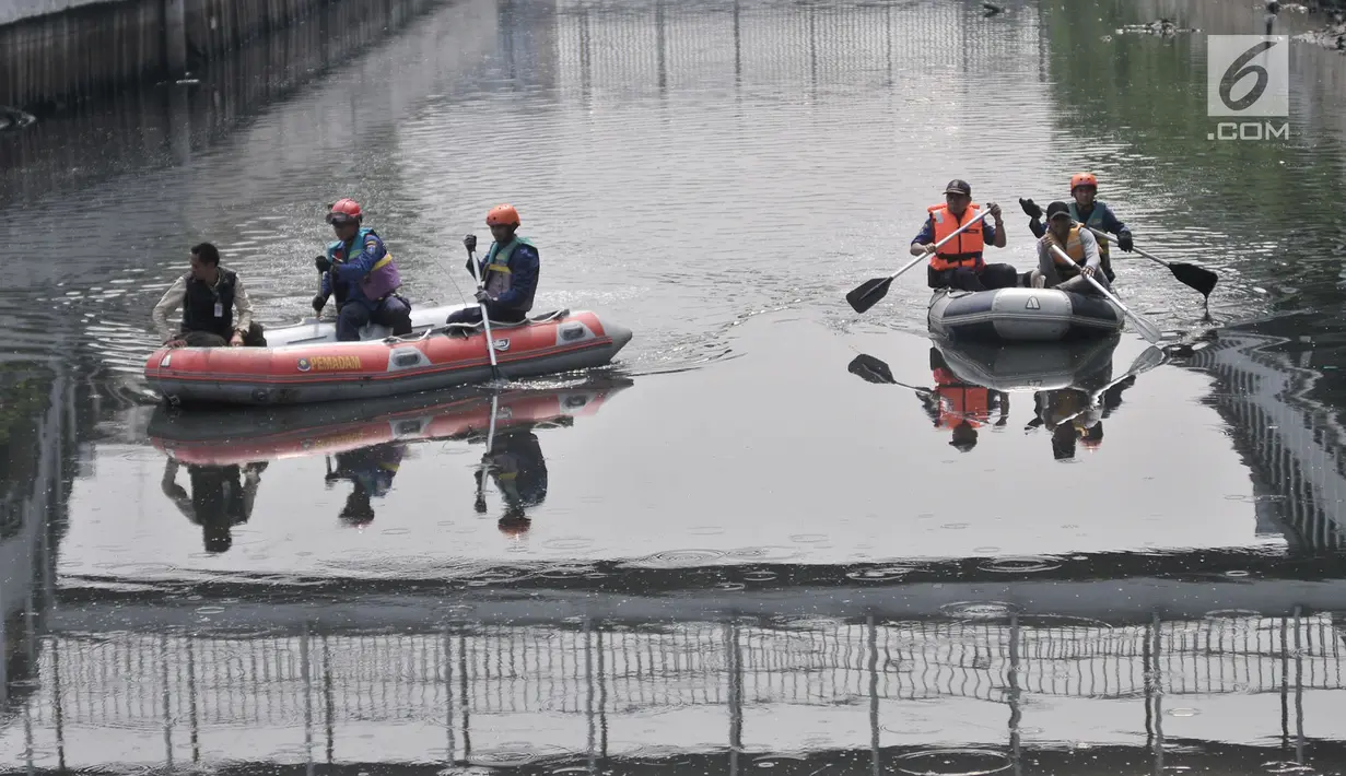 Tim gabungan menyusuri Kali Grogol untuk melakukan pencarian buaya di Jakarta Barat, Kamis (28/6). Untuk memancing buaya keluar dari persembunyiannya, petugas memberi umpan dengan dua ekor ayam dalam upaya penangkapannya. (Merdeka.com/Iqbal S. Nugroho)