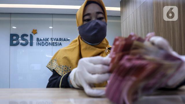 Pekerja menghitung uang di kantor cabang Bank Syariah Indonesia, Jakarta Selasa (2/2/2021). PT Bank Syariah Indonesia Tbk (BSI) resmi beroperasi dengan nama baru mulai 1 Februari 2021. (Liputan6.com/Johan Tallo)