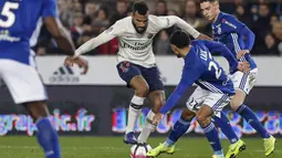 Striker Paris Saint Germain (PSG), Eric Choupo Moting, berusaha melewati pemain RC Strasbourg pada laga Liga 1 Prancis di Stadion Stade de la Meinau, Rabu (5/12). Kedua tim bermain imbang 1-1. (AP/Jean-Francois Badias)