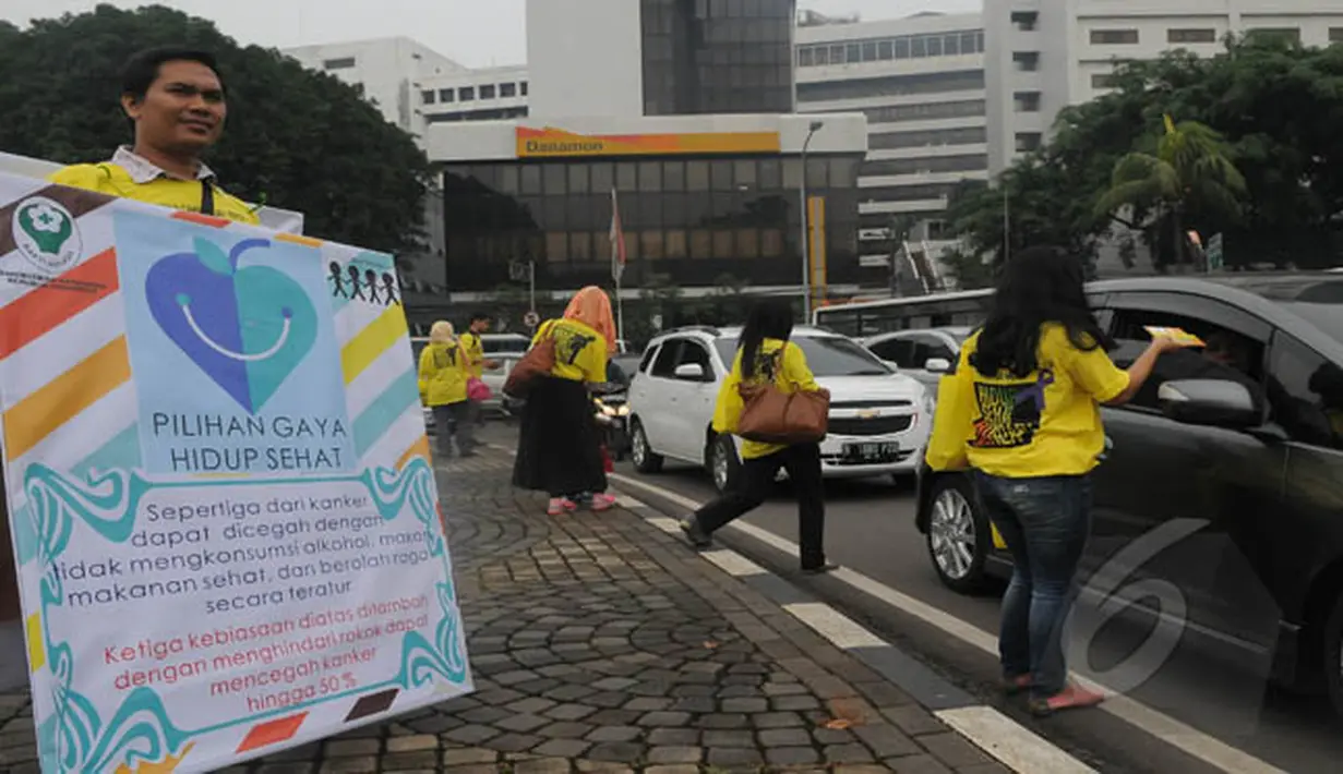 Aksi damai tersebut dengan membagikan bunga dan brosur mengenai kanker kepada pengendara yang lewat di Jalan Bundaran Tugu Tani dan Bundaran Senayan, Jakarta, Rabu (4/2/2015). (Liputan6.com/Herman Zakharia)