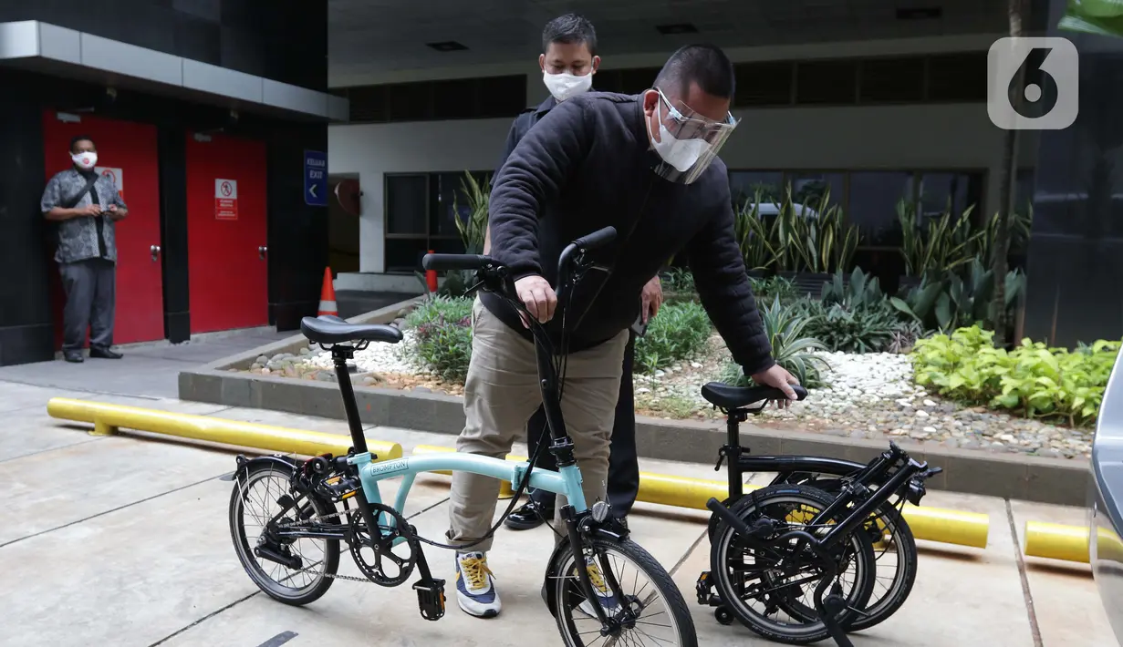 Perantara anggota Komisi II DPR Fraksi PDIP Ihsan Yunus, Agustri Yogasmara membawa sepeda merek Brompton jelang rekonstruksi di Gedung KPK, Jakarta, Rabu (10/2/2021). Agustri menyerahkan dua unit sepeda terkait kasus suap pengadaan bansos untuk Jabodetabek 2020. (Liputan6.com/Helmi Fithriansyah)