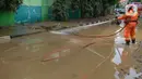 Petugas pemadam kebakaran membersihkan sisa lumpur pascabanjir yang merendam kawasan Bukit Duri, Jakarta, Sabtu (4/1/2020). Meski banjir sudah mulai surut, jalan-jalan dan permukiman warga masih tertutup lumpur tebal. (merdeka.com/Imam Buhori)