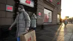 Seorang perempuan membawa kantong belanja setelah meninggalkan toko utama H&M di Moskow, Rusia, Rabu (30/11/2022). Pengecer mode no.2 dunia itu akhirnya menutup semua tokonya di Rusia untuk selamanya. (AP Photo/Alexander Zemlianichenko)