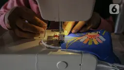 Perajin menyelesaikan pembuatan masker batik di Butik Elemwe, Jakarta, Jumat (2/10/2020). Spesifikasi masker kain ber-SNI terbagi menjadi tiga tipe antara lain tipe A untuk penggunaan umum, tipe B penggunaan filtrasi bakteri, dan tipe C penggunaan filtrasi partikel. (Liputan6.com/Faizal Fanani)
