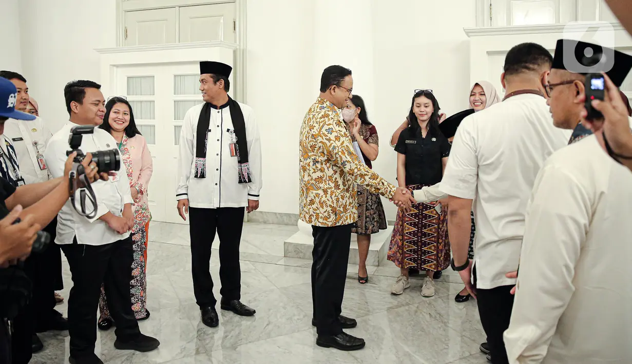 Gubernur DKI Jakarta Anies Baswedan (tengah kanan) menyapa para Aparatur Sipil Negara (ASN) di Balai Kota DKI Jakarta, Jumat (14/10/2022). Di hari terakhir menjabat sebagai Gubernur DKI Jakarta, Anies Baswedan menyempatkan diri untuk menyapa ASN di Balai Kota. (Liputan6.com/Faizal Fanani)