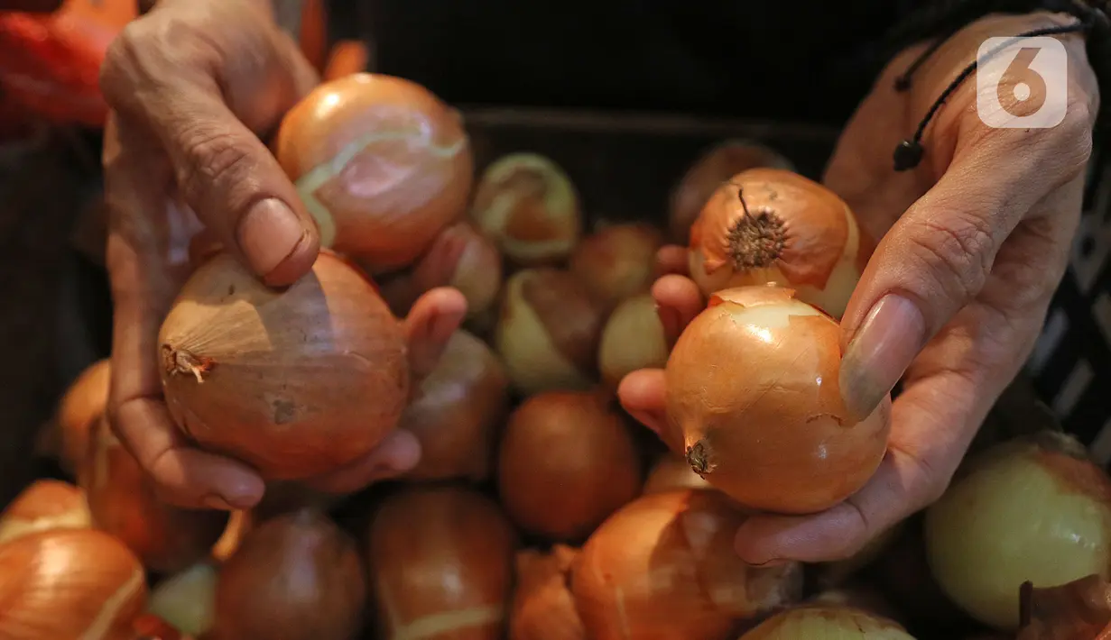 Pedagang memperlihatkan bawang bombay dagangannya di dPasar Induk Kramat Jati, Jakarta, Kamis (12/3/2020). Para pedagang di pasar tradisional, mengeluhkan harga bawang bombay yang melonjak drastis hingga 10 kali lipat dari harga normal. (Liputan6.com/Herman Zakharia)