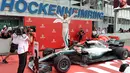 Pembalap Mercedes, Lewis Hamilton berselebrasi setelah berhasil finish pertama pada balapan F1 GP Jerman di Sirkuit Hockenheim, Minggu (22/7). Kemenangan ini diraih secara dramatis karena Hamilton mengawali balapan dari urutan ke-14. (AP/Jens Meyer)