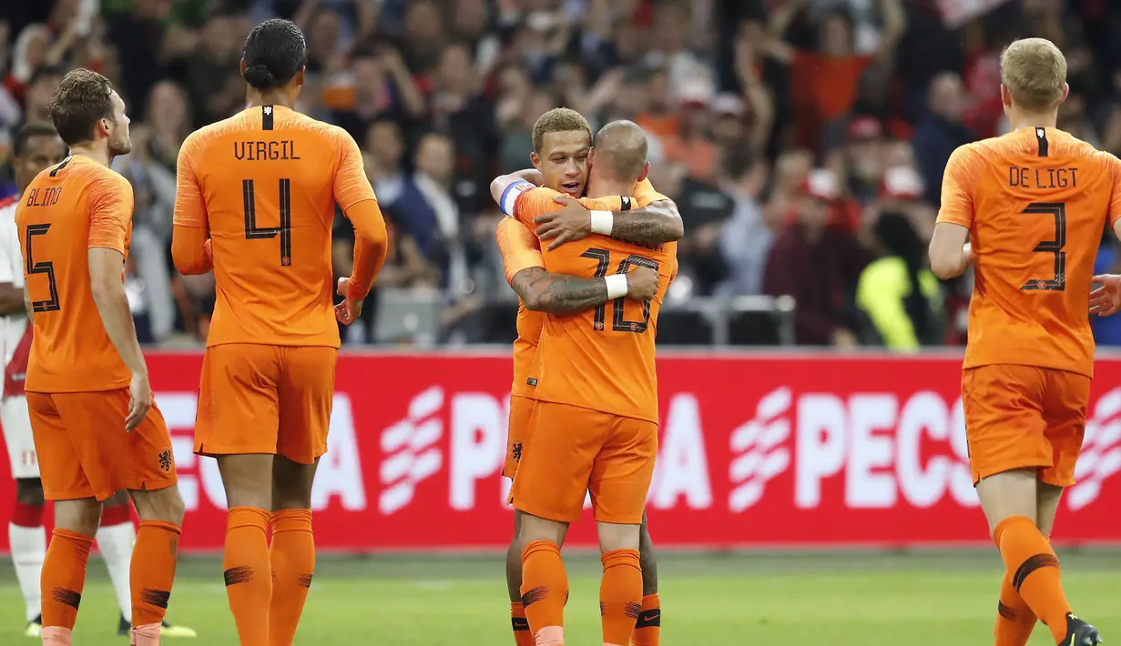 Gelandang Timnas Belanda, Wesley Sneijder (dua kanan) memeluk rekan setimnya usai laga persahabatan melawan Peru di Amsterdam, Kamis (6/9). Selama membela Belanda, Sneijder telah mencatatkan 134 penampilan dan menyumbang 31 gol. (KOEN VAN WEEL/ANP/AFP)