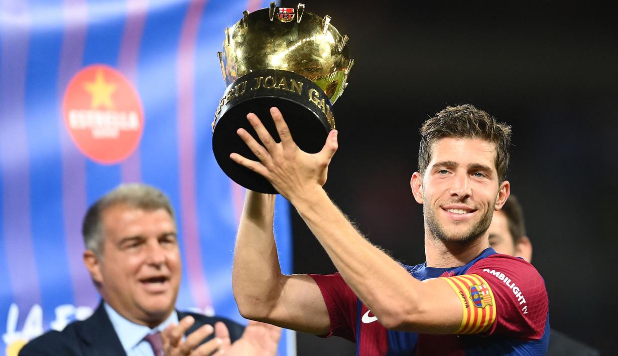 Pemain Barcelona, Sergi Roberto mengangkat trofi Piala Joan Gamper edisi ke-58 setelah mengalahkan Tottenham Hotspur dengan skor 4-2di Estadi Olimpic Lluis Companys, Barcelona, 8 Agustus 2023. (AFP/Pau Barrena)