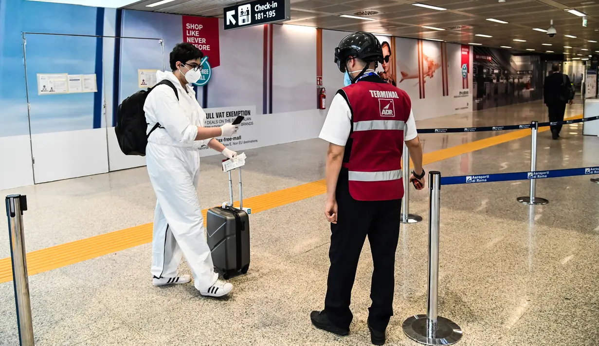 Petugas mengenakan termoscanner portabel "Smart-Helmet" untuk memeriksa suhu penumpang dan sesama staf di terminal keberangkatan bandara Fiumicino Roma, Italia pada 5 Mei 2020. Hal ini dilakukan guna menyaring orang yang memiliki gejala infeksi virus corona. (ANDREAS SOLARO/AFP)