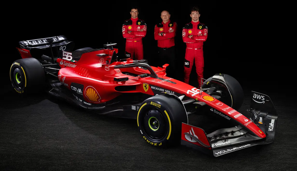 Pebalap Scuderia Ferrari Carlos Sainz Jr (kiri) dan Charles Leclerc bersama Team principal Frederic Vasseur (tengah) berpose di samping mobil baru Ferrari SF-23 untuk Formula 1 2023 di Maranello 14 Februari 2023. (AFP/Ferrari Press Office)