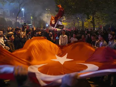 Pendukung Presiden Recep Tayyip Erdogan merayakan di luar markas Partai Keadilan dan Pembangunan ( AKP) di Istanbul, Turki, Minggu (14/5/2023). (AP Photo/Khalil Hamra)
