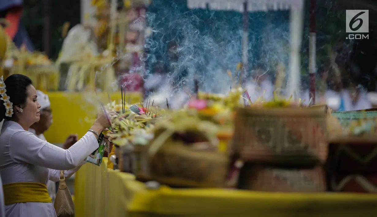 Umat Hindu meletakan dupa selama prosesi upacara Tawur Agung Kesanga 2019 di Pura Aditya Jaya Rawamangun, Jakarta, Rabu (6/3). Prosesi Tawur Agung merupakan rangkaian perayaan Hari Raya Nyepi Tahun Baru Saka 1941. (Liputan6.com/Faizal Fanani)