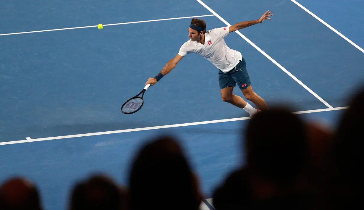 Petenis Swiss, Roger Federer berusaha mengembalikan bola ke arah Taylor Fritz dari AS dalam babak 32 besar Australia Terbuka di Melbourne, Jumat (18/1). Federer melaju mulus ke babak 16 besar setelah menang tiga set langsung 6-2 7-5 6-2. (AP/Kin Cheung)