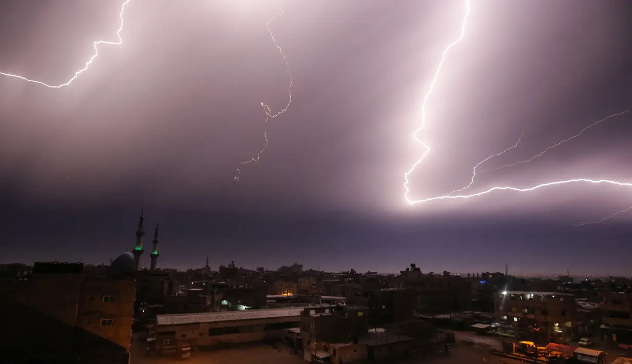 Kilatan petir terlihat saat hujan lebat di atas kota Rafah di Jalur Gaza selatan, Palestina, Kamis (16/1/2020). (AFP/Said Khatib)