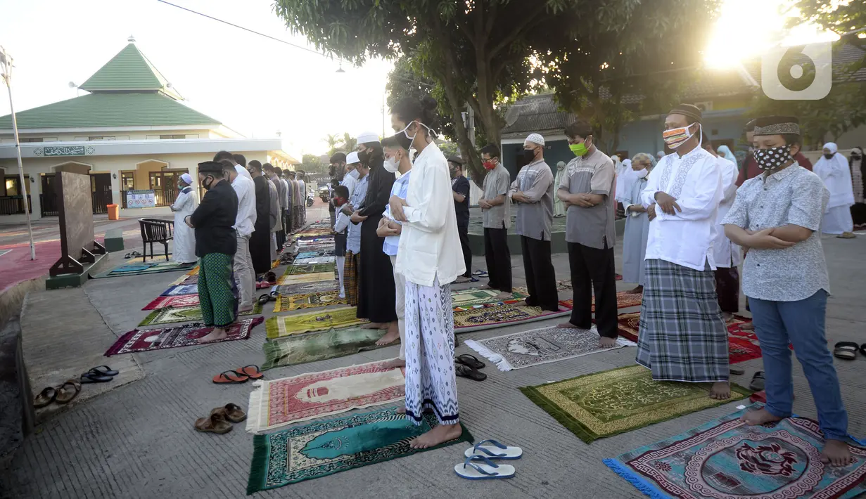 Jemaah melaksanakan salat Idul Fitri di pelataran Masjid Al Kahfi Griya Pamulang 2, Parakan, Pamulang, Tangerang Selatan, Banten, Minggu (24/5/2020). Di tengah pandemi virus corona COVID-19, jemaah yang hadir mengenakan masker untuk mencegah penularan. (merdeka.com/Dwi Narwoko)