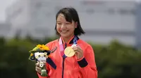 Skater Jepang Momiji Nishiya memegang medali emas setelah memenangkan final street skateboarding putri Olimpiade Tokyo 2020 di Tokyo, Jepang, 26 Juli 2021. Saat ini, Momiji tercatat sebagai atlet termuda yang sukses mendulang emas di Olimpiade. (AP Photo/Ben Curtis)