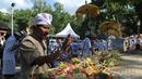 Umat Hindu meletakkan sesajen saat hendak berdoa selama perayaan Kuningan di sebuah pura di Pulau Serangan, Denpasar, Bali, Sabtu (20/2). Kuningan merupakan hari terakhir dari perayaan Galungan. (AFP PHOTO/SONNY Tumbelaka)