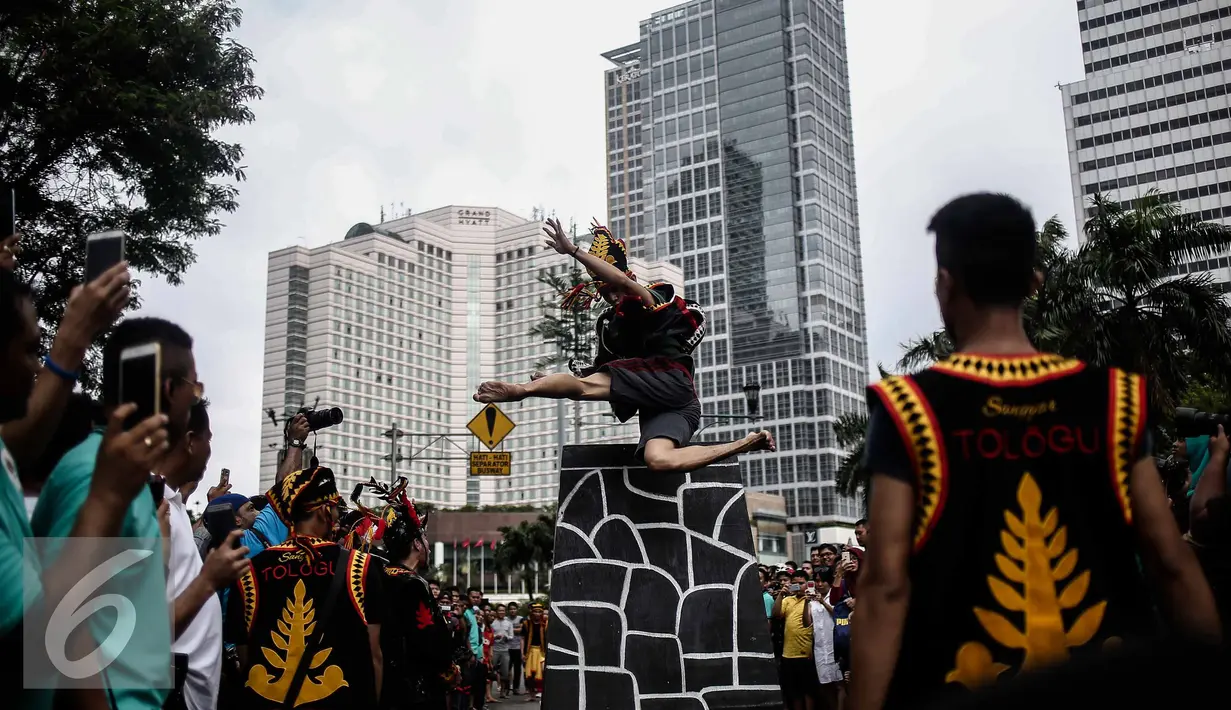 Atraksi seorang pria saat melakukan fahombo atau lompat batu dalam sebuah acara pagelaran seni dan kebudayaan Nias di Jalan Imam Bonjol, Jakarta, Minggu (12/2). Pagelaran ini diselenggarakan oleh Pemuda Peduli Nias. (Liputan6.com/Faizal Fanani)