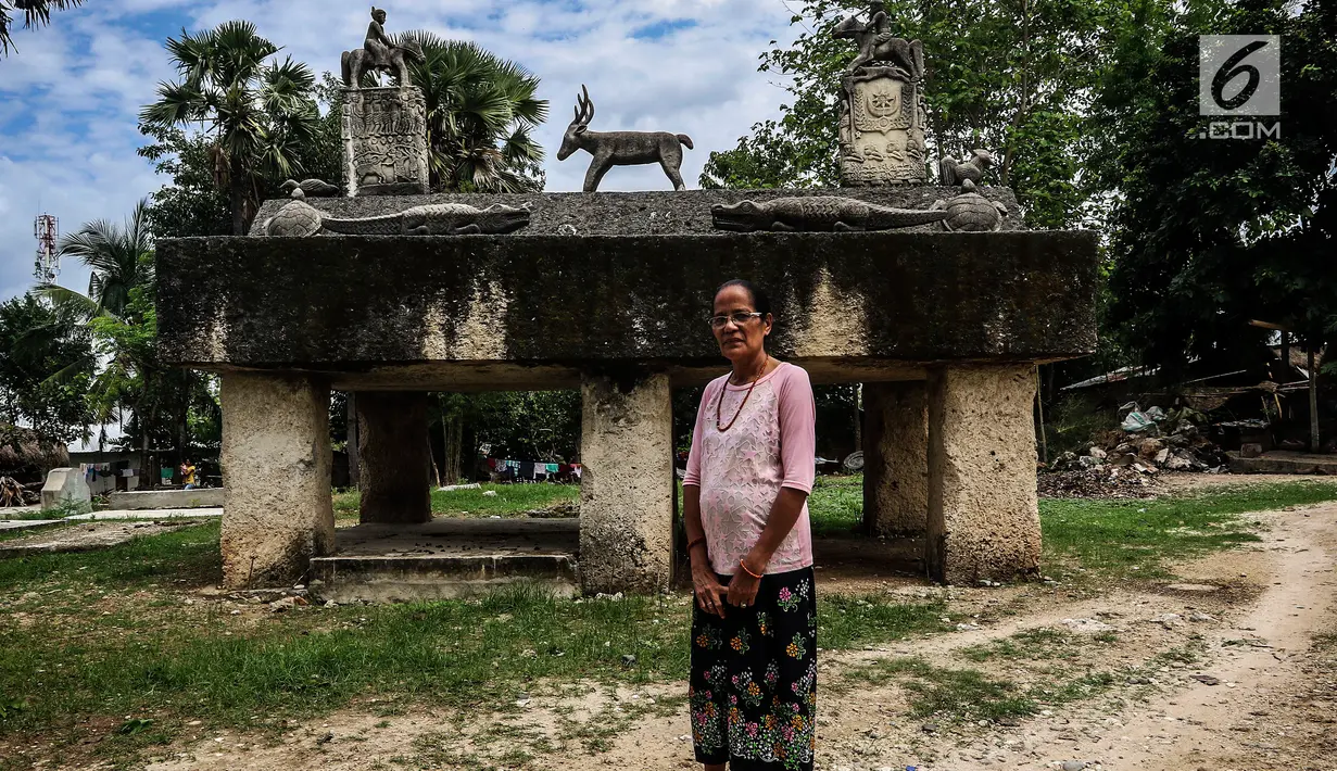 Seorang Ibu bernama Tamu Rambu Margaretha (dipanggil "Mama Margareth")  berfoto di depan Kuburan Raja. Mama Tamu Rambu Margaretha adalah salah seorang dari keturunan raja di desa adat Prailiu. (Liputan6.com/Johan Tallo)