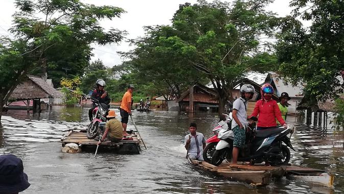 Bencana banjir Konawe, selain merendam rumah, sejumlah pengendara masih terhalang banjir dan harus dibantu rakit.(Liputan6.com/Ahmad Akbar Fua)