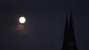 Fenomena Supermoon terlihat terbit di atas menara gereja Familienkirche di Wina, Selasa (9/9/14). (REUTERS/Heinz-Peter Bader)