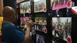 Pengunjung mengambil gambar karya-karya foto pemenang Anugerah Jurnalistik Polri 2018 yang dipamerkan di Gandaria City, Jakarta, Rabu (18/7). Terdapat 641 peserta yang mengikuti lomba melalui karya jurnalistik, foto dan komik. (Liputan6.com/Arya Manggala)