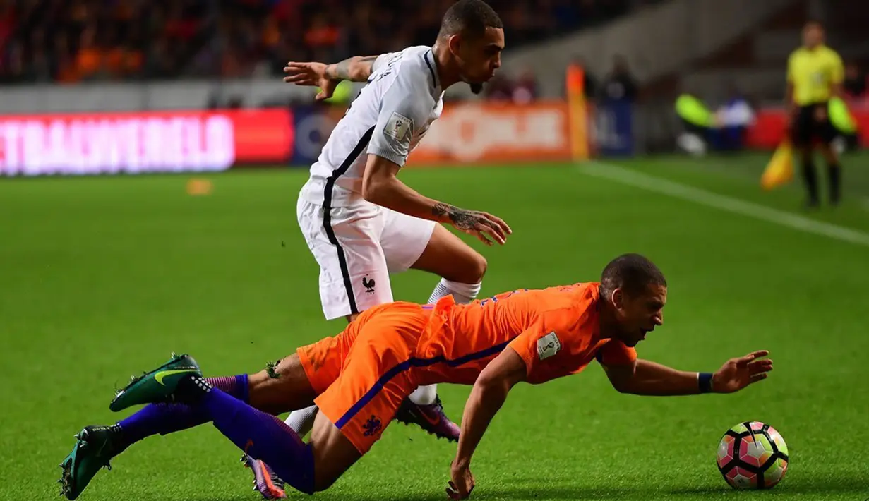 Pemain Belanda, Jeffrey Bruma (kanan), berebut bola dengan pemain Prancis, Layvin Kurzawa, pada laga Grup A Kualifikasi Piala Dunia 2018 zona Eropa, di Amsterdam ArenA, Selasa (11/10/2016) dini hari WIB. (AFP/Emmanuel Dunand)