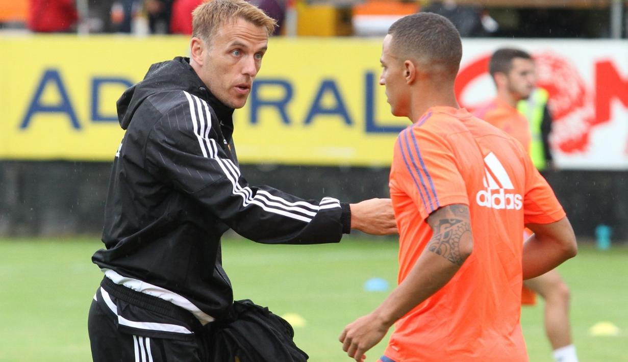 Asisten pelatih Valencia, Phil Neville, memberikan arahan kepada Rodrigo saat pemanasan. (Bola.com/Reza Khomaini)