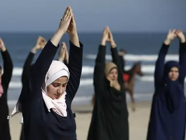 Sejumlah wanita Palestina berlatih yoga di pantai di Gaza City (3/3/2020). Pelatihan yoga tersebut diselenggarakan oleh Positive Energy Club. (AFP Photo/Mohammed Abed)