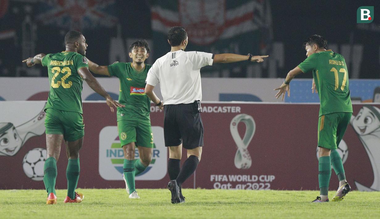 Wasit Yudi Nurcahya menunjuk titik putih penalti setelah Pemain PSS Sleman, Marckho Sandi Merauje (kiri), melanggar pemain Persis Solo, Muhammad Abduh Lestaluhu, dalam lanjutan pertandingan babak penyisihan Grup A Piala Presiden 2022 di Stadion Manahan, Solo, Jawa Tengah, Sabtu (11/6/2022). (Bola.com/Arief Bagus)