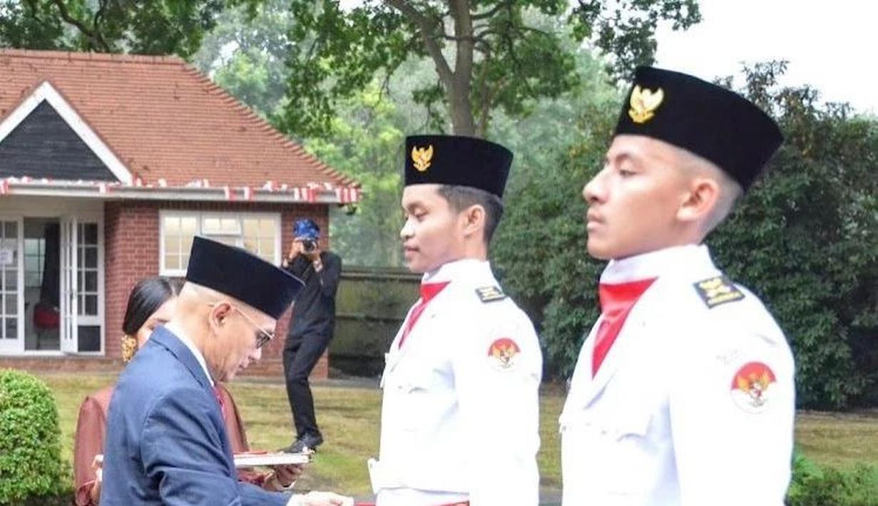 Reiki alias Eki, putra Ratna Listy disempatkan sebuah kain di pinggangnya oleh Desra Percaya, Duta Besar RI di London jelang upacara. (Foto: Instagram/@ratna_listy)