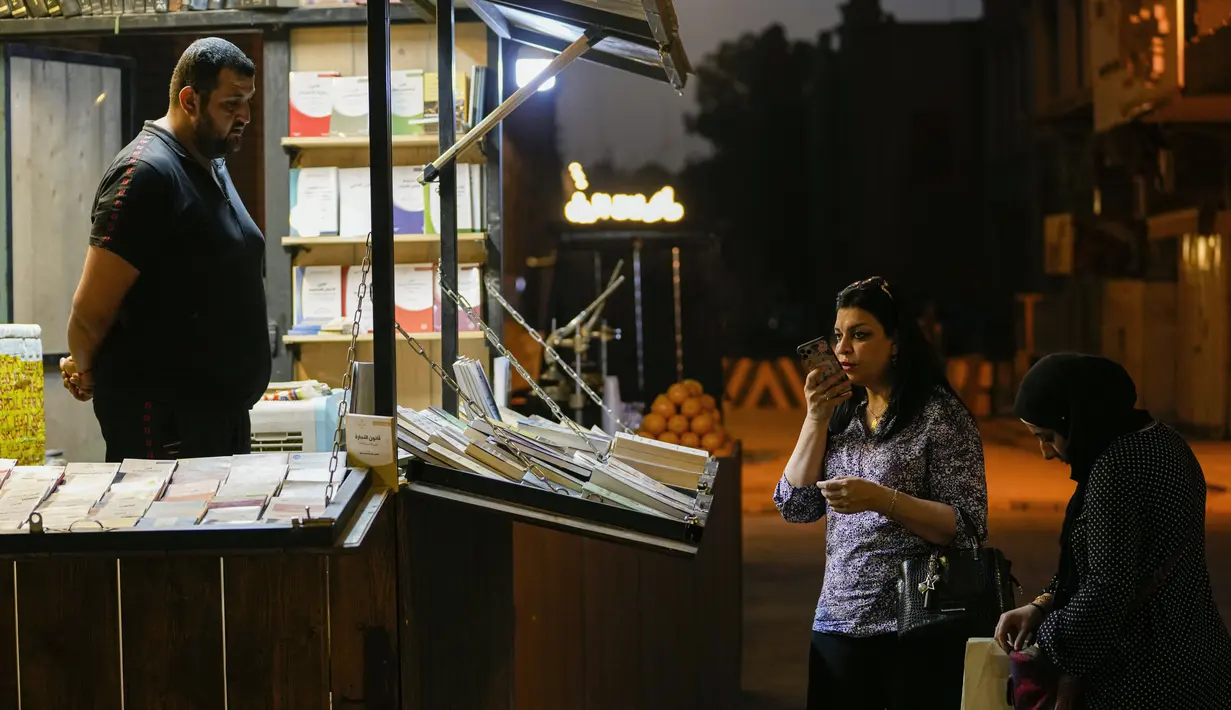 Warga Irak mencari buku di pasar buku di Jalan Mutanabi Baghdad, Irak (18/5/2022). Jalan Al-Mutanabbi pertama kali diresmikan pada 1932 oleh Raja Faisal I dan diberi nama berdasarkan penyair abad ke-10 Abul Tayeb al-Mutanabbi. (AP Photo/Hadi Mizban)