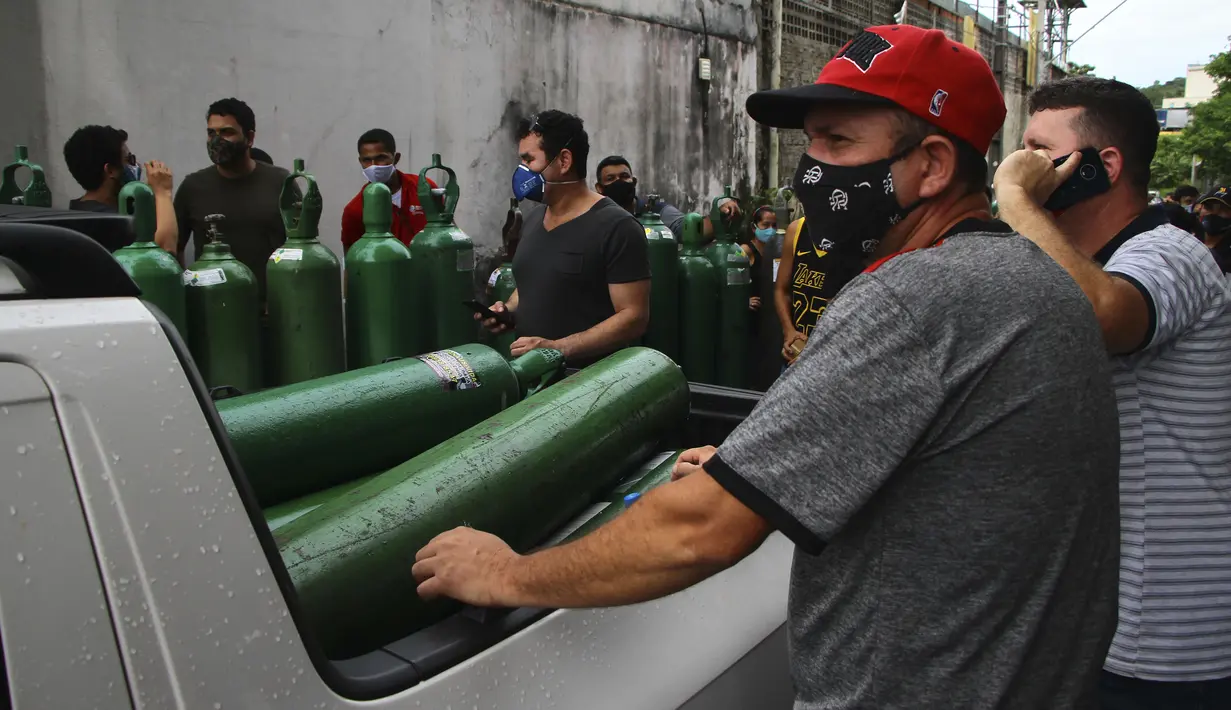 Antrean keluarga pasien COVID-19 yang dirawat di rumah sakit dengan membawa tangki oksigen kosong untuk mengisi kembali di Manaus, negara bagian Amazonas, Brasil, 15 Januari 2021. Negara Bagian Amazonas di Brasil kehabisan oksigen karena semakin melonjaknya pasien Covid-19. (AP Photo/Edmar Barros)