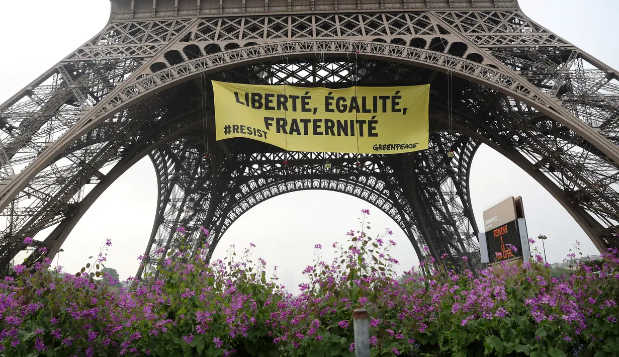 Sebuah spanduk bertuliskan "Kebebasan, Kesetaraan, Persaudaraan" terpampang di Menara Eiffel di Paris, Prancis, Kamis (5/5). (AFP/Jacques DEMARTHON)