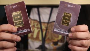 Karyawan menunjukkan kepingan emas yang dijual di Galeri 24, Jakarta, Selasa (15/12/2020). Harga emas hasil produksi PT Aneka Tambang Tbk (Antam) atau emas Antam kini turun Rp 1.000 per gram menjadi Rp 951 per gram pada perdagangan, Selasa (15/12). (Liputan6.com/Angga Yuniar)