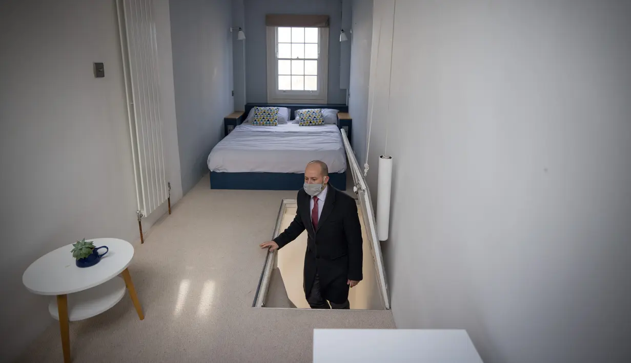 Agen real estate David Myers memimpin tur berkeliling "Rumah Tersempit di London" di London barat pada 5 Februari 2021. Rumah tersempit ini menampung banyak ruangan, termasuk tiga kamar tidur, teras atap, kamar mandi, taman, hingga dapur dan ruang tamu di lantai bawah tanah. (Tolga Akmen/AFP)