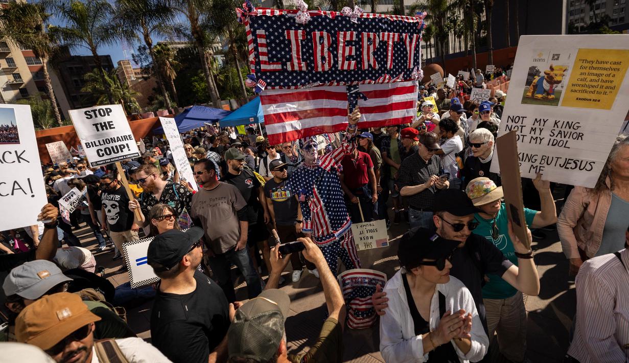 Saat berunjuk rasa, para demonstran membawa poster bertuliskan "Not My President!", "Fascism has Arrived," "Stop Evil," dan "Hands Off Our Social Security.". (ETIENNE LAURENT/AFP)