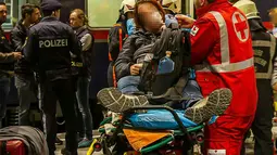 Seorang penumpang mendapatkan perawatan dari tim medis usai dua gerbong kereta bertabrakan di Salzburg, Austria (20/4). Dua gerbong kereta penumpang di Austria bertabrakan saat akan dipasangkan menjadi satu rangkaian. (FMT/Wolfgang Moser/APA/AFP)