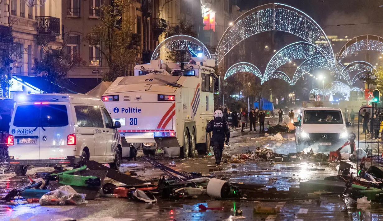 Mobil polisi melewati jalan raya utama saat kerusuhan pecah selama dan setelah kemenangan Maroko atas Belgia pada pertandingan sepak bola Piala Dunia 2022 di Brussel, Belgia, 27 November 2022. Polisi harus menutup sebagian pusat Kota Brussel dan bergerak dengan meriam air serta gas air mata untuk membubarkan massa. (AP Photo/Geert Vanden Wijngaert)