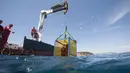 Sebuah derek digunakan untuk mengambil peti berisi botol anggur di dasar Laut Mediterania di Saint-Mandrier, Prancis selatan, 15 Mei 2017. Penyelam Prancis melakukan percobaan proses pematangan anggur di dalam air selama setahun. (Boris HORVAT/AFP)