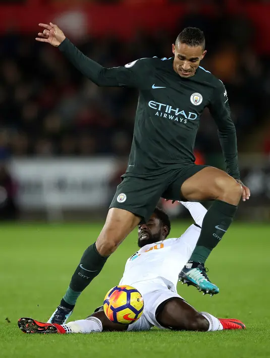 Pemain Manchester City, Danilo berusaha merebut bola dari pemain Swansea City, Nathan Dyer pada lanjutan Premier League di Liberty Stadium, Rabu (13/12). Bertandang ke Swansea City, Manchester City menang telak 4-0. (Nick Potts/PA via AP)