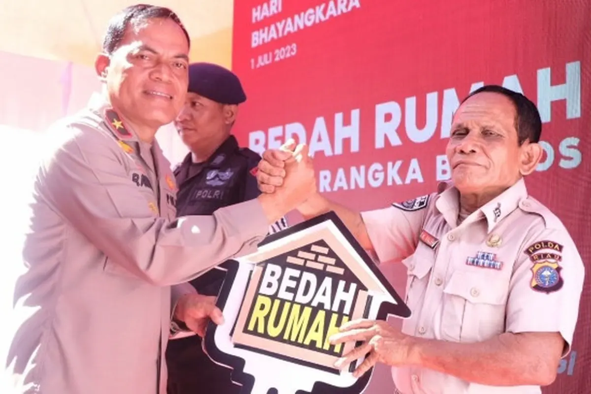 Seorang PNS mendapatkan kunci bedah rumah Polda Riau menjelang puncak peringatan Hari Bhayangkara.