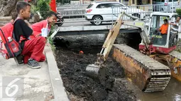 Anak-anak menonton pengerukan lumpur di Kali Baru Barat di jalan Dr Saharjo, Menteng Atas, Jakarta, Selasa (23/2). Ditargetkan pengerukan lumpur di kali tersebut dapat dirampungkan dalam waktu satu pekan. (Liputan6.com/Yoppy Renato)
