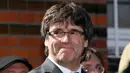 Mantan pemimpin Catalan, Carles Puigdemont tersenyum sebelum memberi keterangan kepada awak media setelah dibebaskan dengan jaminan dari penjara di Neumuenster, Jerman utara, (6/4). (Carsten Rehder / dpa via AP)