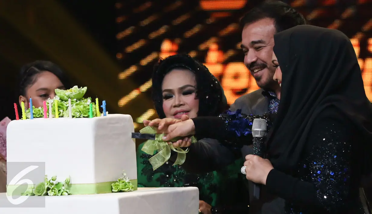 Siti Nurhaliza bersama suami memotong kue ulang tahun saat mengisi acara Golden Memories International di studio 5 Indosiar, Jakarta, Kamis (12/1). (Liputan6.com/Yoppy Renato)