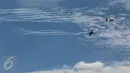 Aksi udara dari pesawat tempur yang menghindari serangan pesawat musuh dalam perayaan HUT TNI Angkatan Udara (TNI AU) ke-71 di Landasan Udara (Lanud) Bandara Halim Perdanakusuma, Jakarta, Minggu (9/4). (Liputan6.com/Faizal Fanani)